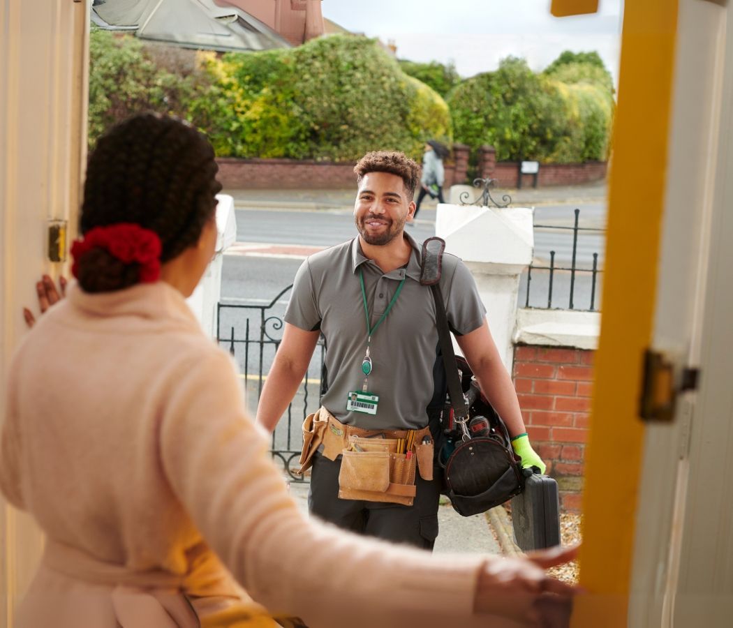 A man is standing in a doorway talking to a woman.