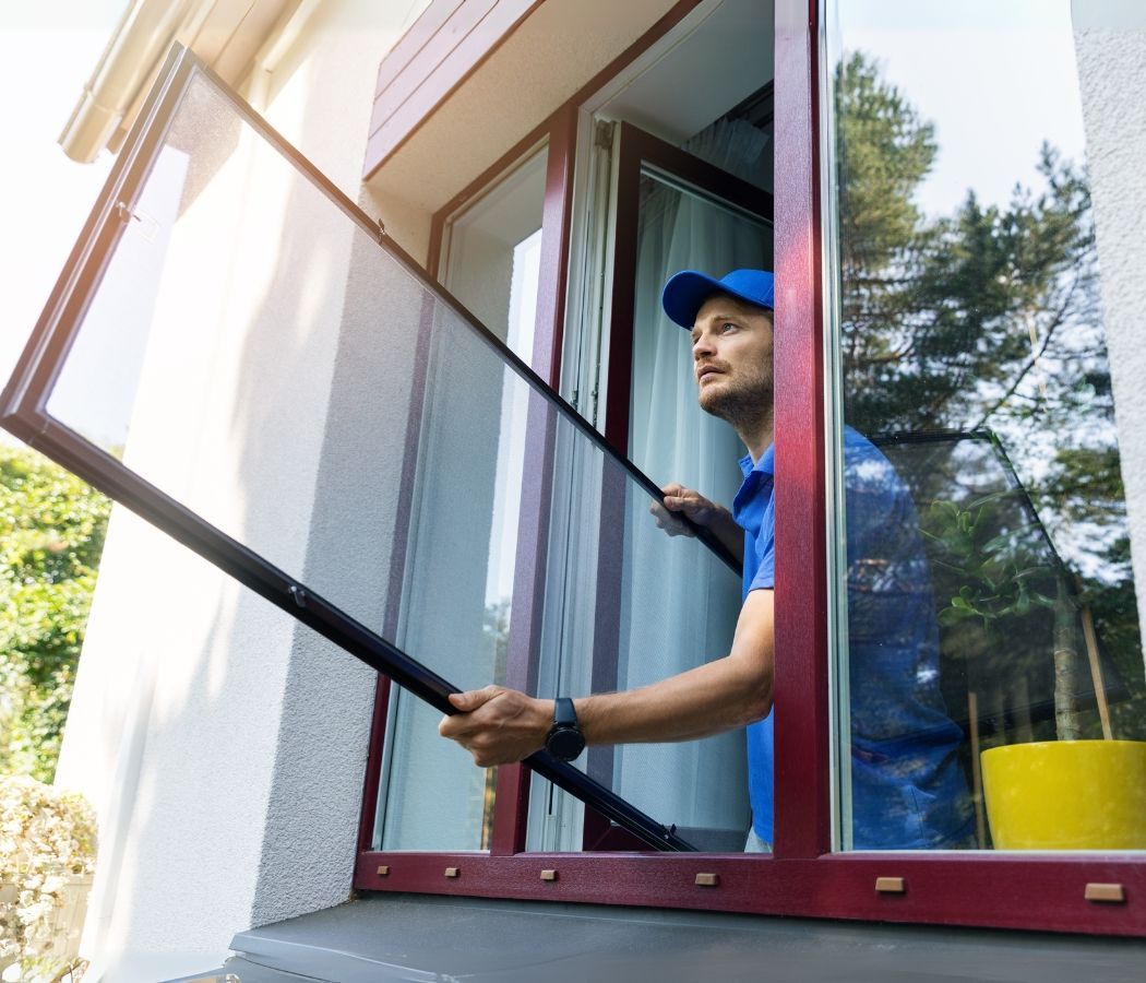 A man is cleaning a window with a broom