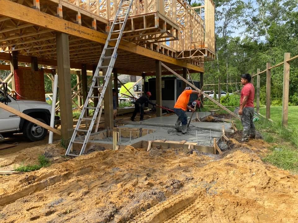 A group of construction workers are working on a house under construction.