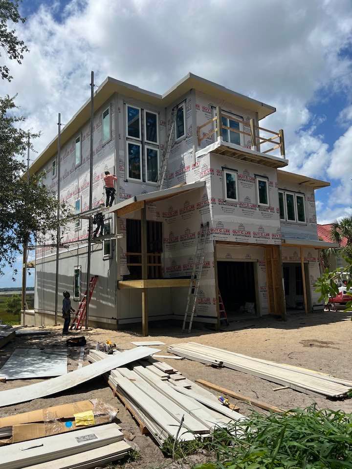 A large house is being built on a sunny day.