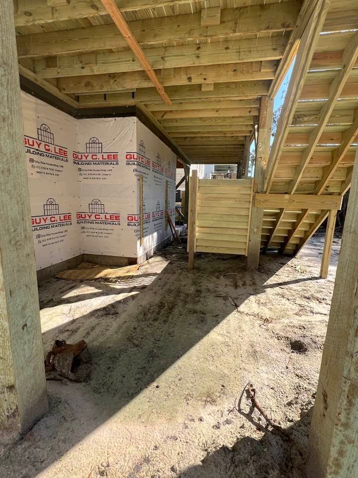 Wooden deck under construction with stairs and a small enclosed area.