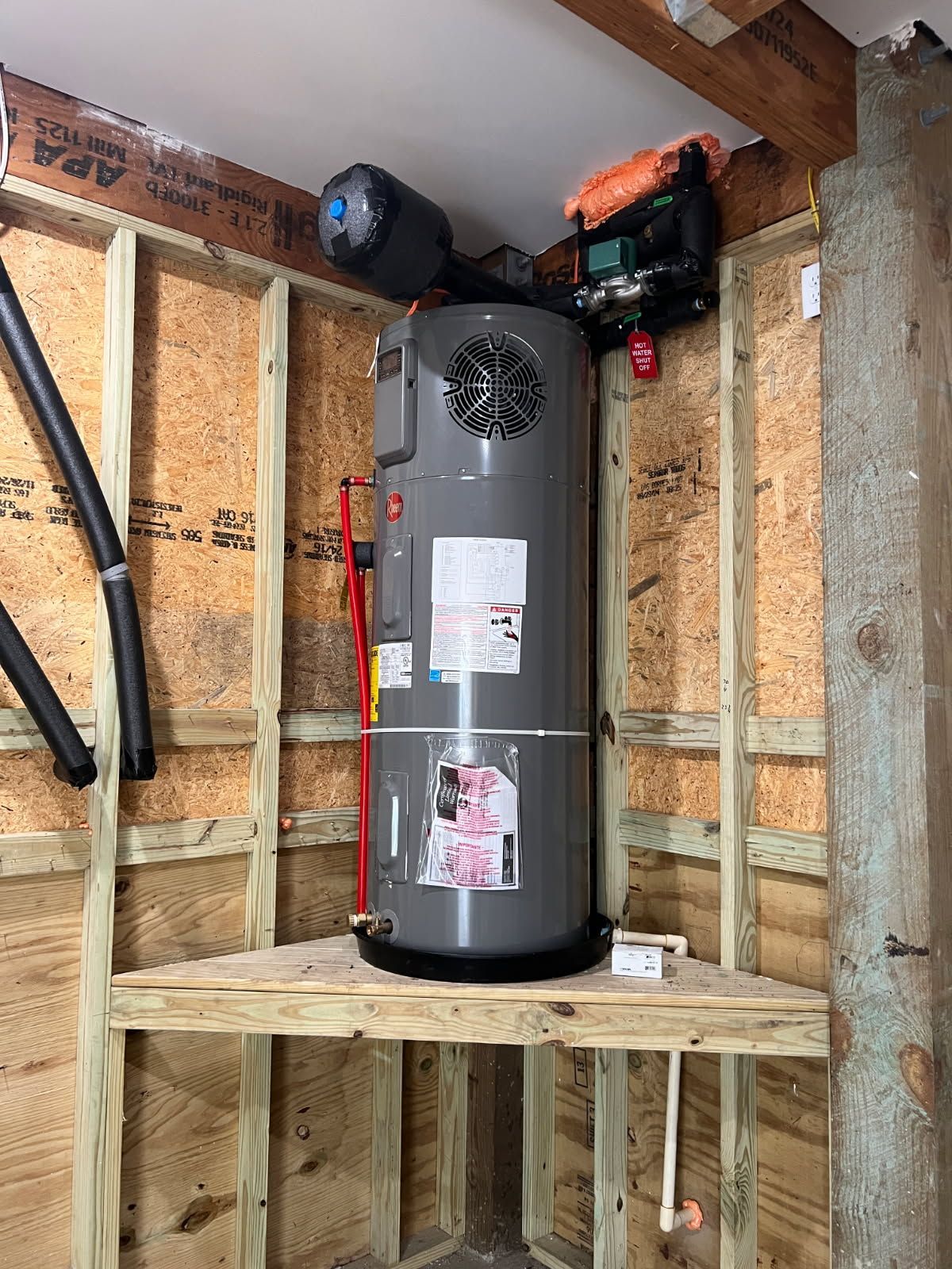 Water heater inside a wooden framed corner.