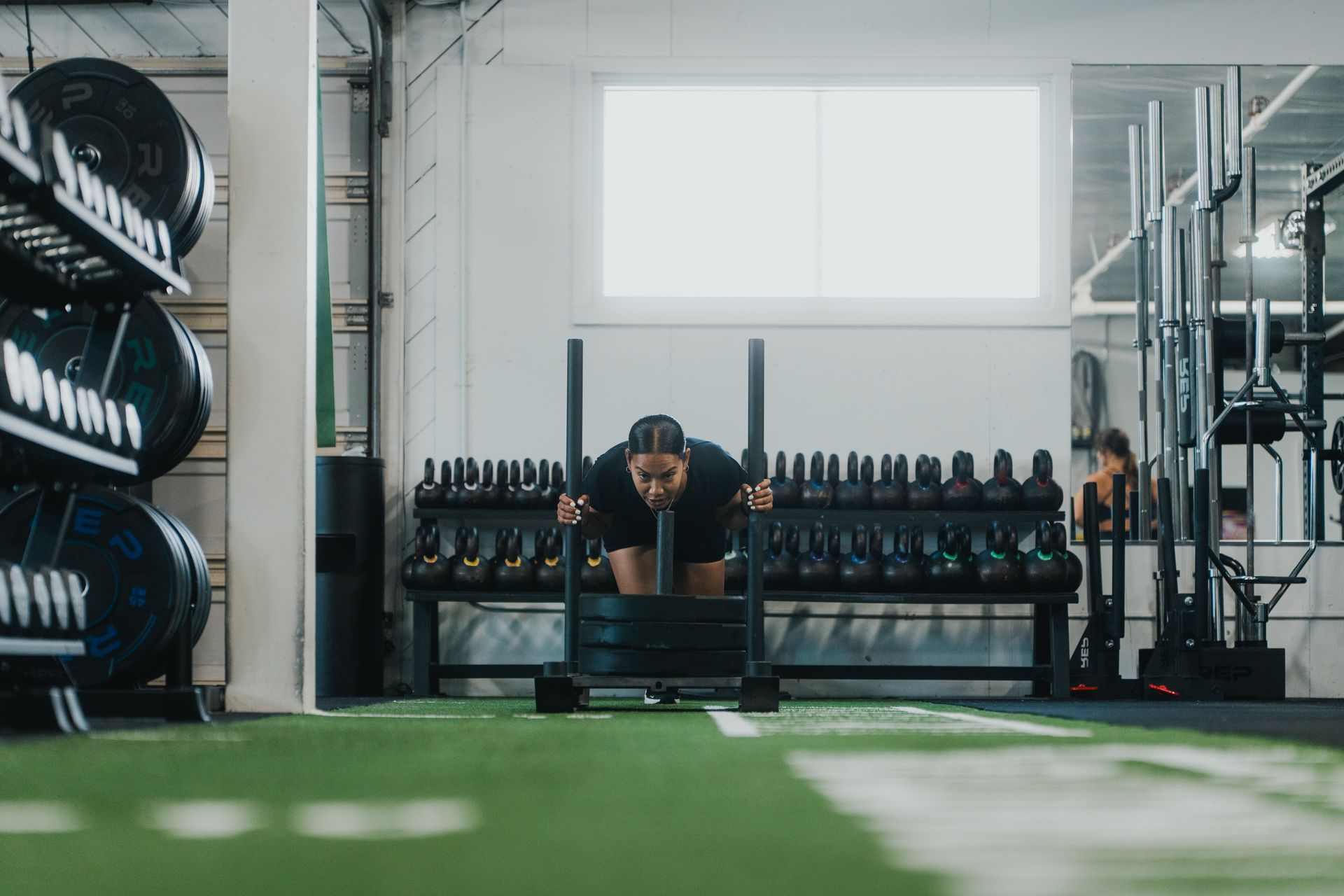 A woman is riding an exercise bike in a gym.