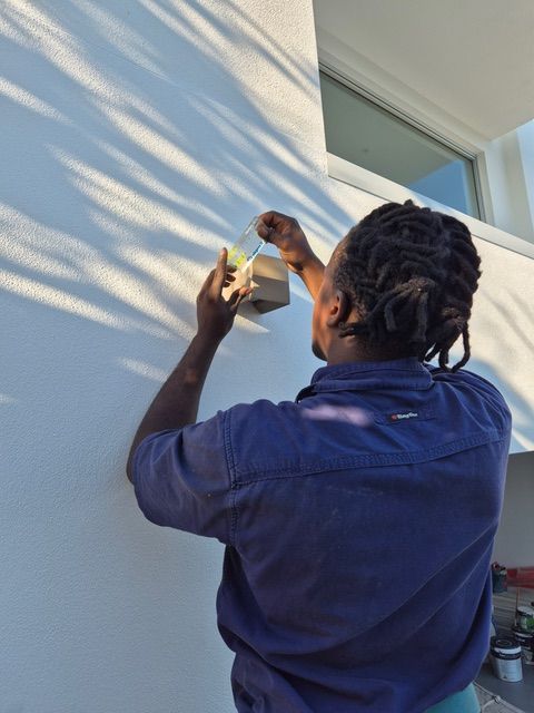 Electrician working on the outside of a home— Powered By JBES In Sandgate, NSW
