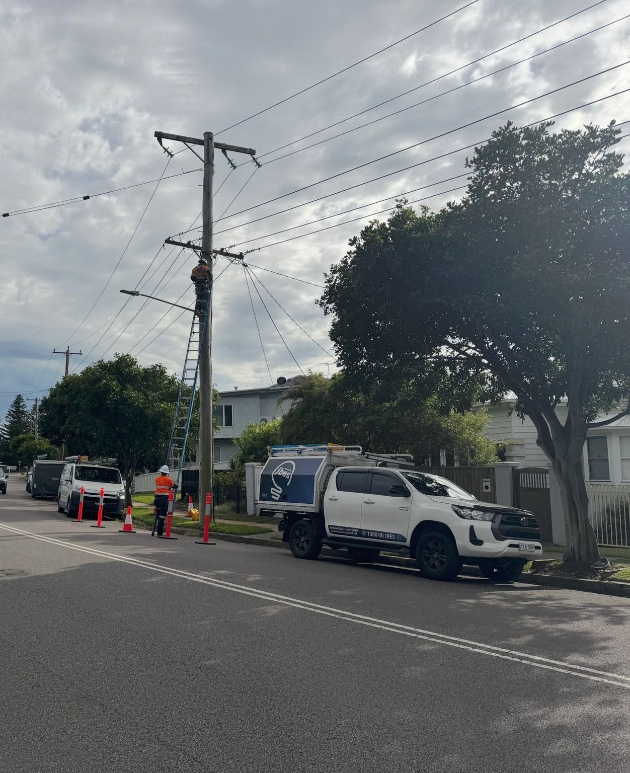 Linemen Working on Power Lines Atop a Wooden Pole — Powered By JBES In Sandgate, NSW