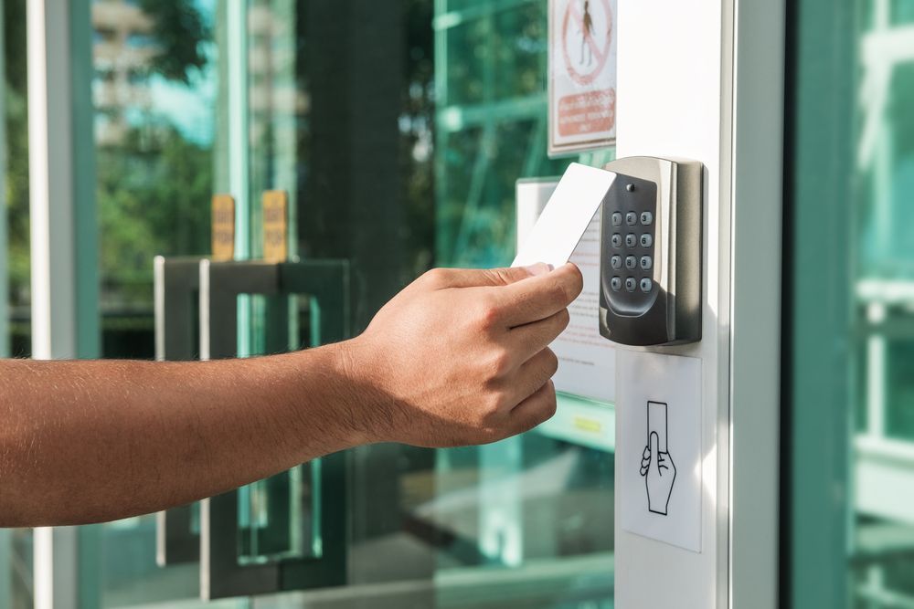 Hand Swiping a White Access Card on a Door Reader — Powered By JBES In Sandgate, NSW