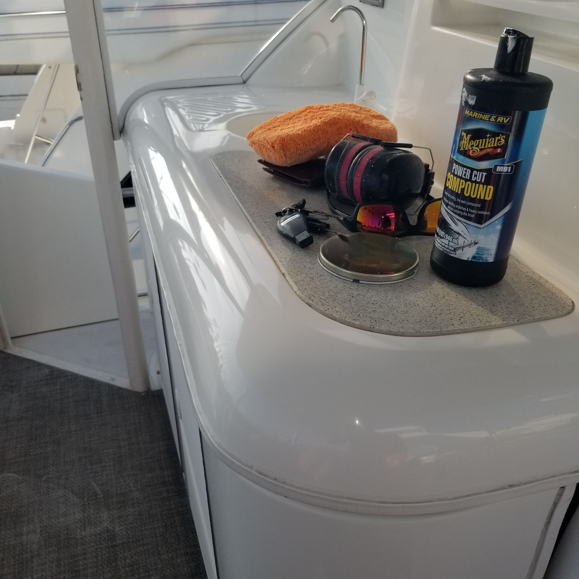 Boat deck with detailing supplies: compound, sponge, and a can.