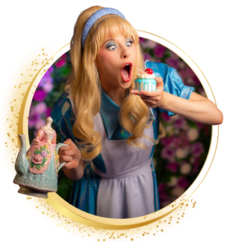 Blonde pop in een blauwe jurk houdt een cupcake vast, vol verbazing, naast een versierde taart in een bloemrijke omgeving.