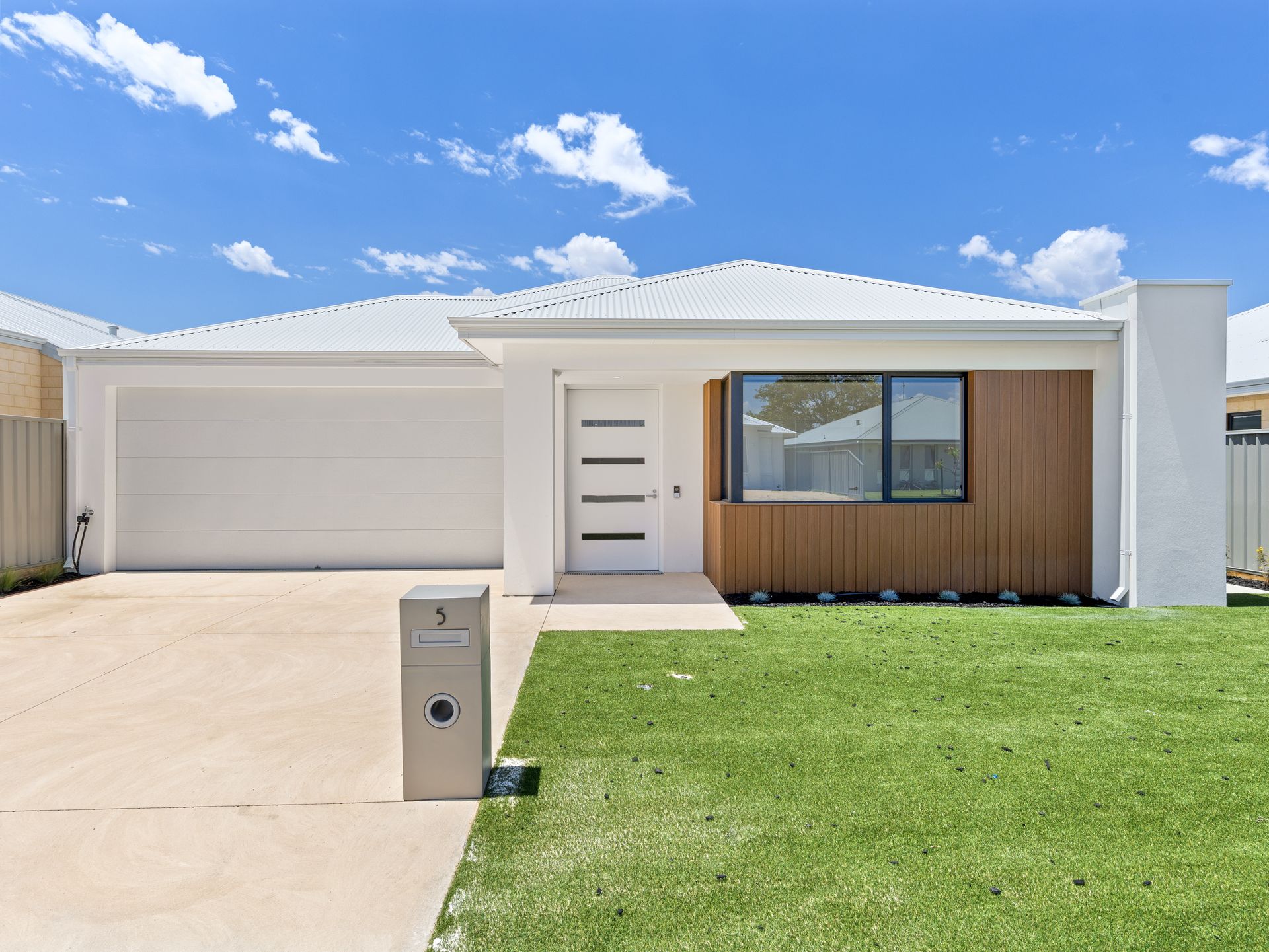 A single-story suburban house under a blue sky, with text at the bottom reading