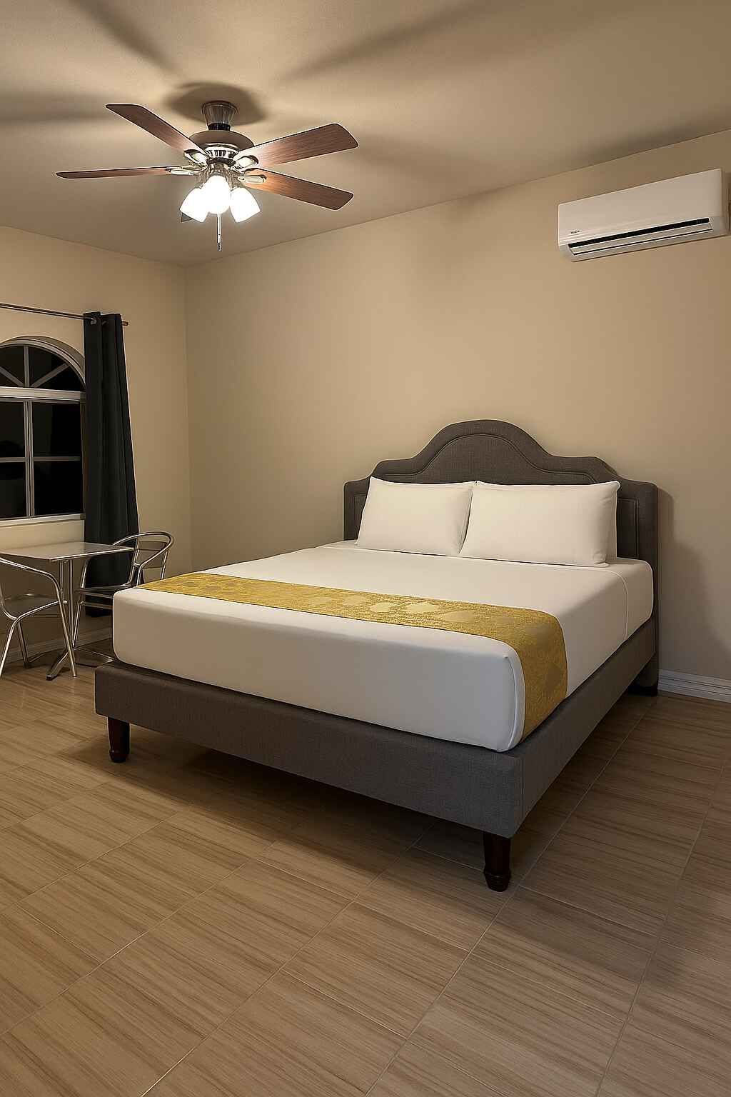 A bedroom with a king size bed and a ceiling fan.