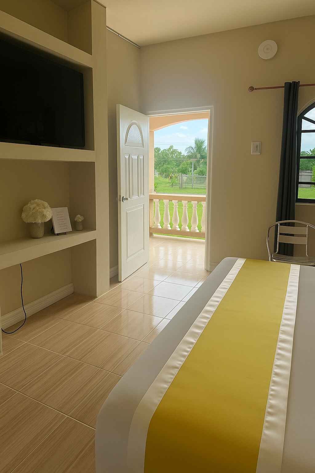 A bedroom with a bed , television , and balcony.