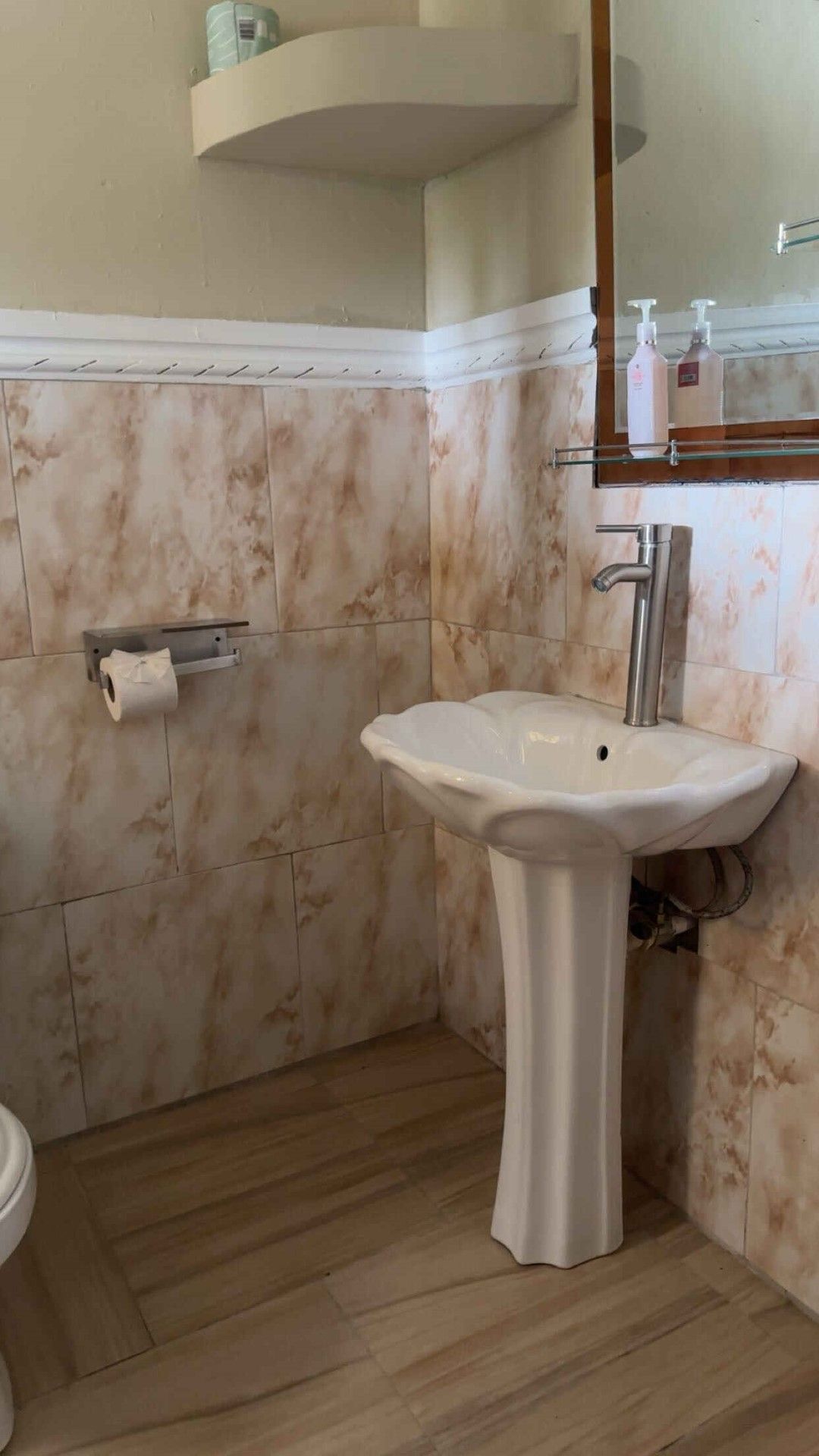 A bathroom with a sink , toilet and mirror.