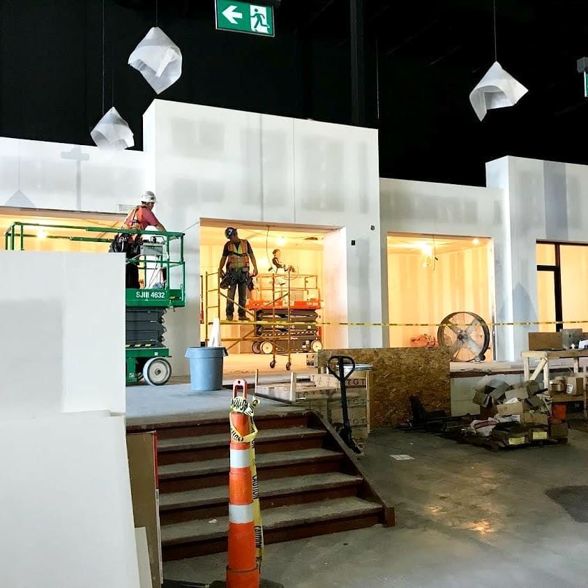 A construction site with a green exit sign pointing to the right