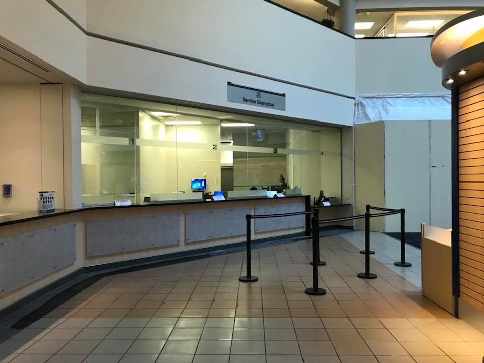 An empty lobby of a building with a counter and a window