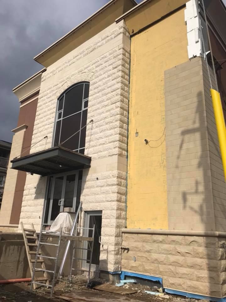 A building under construction with a yellow wall and stairs.