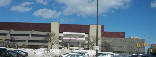 A parking lot with cars parked in front of a large building