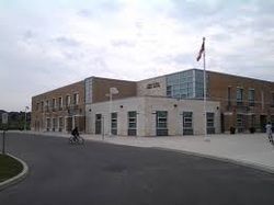A man is riding a bike in front of a large building.