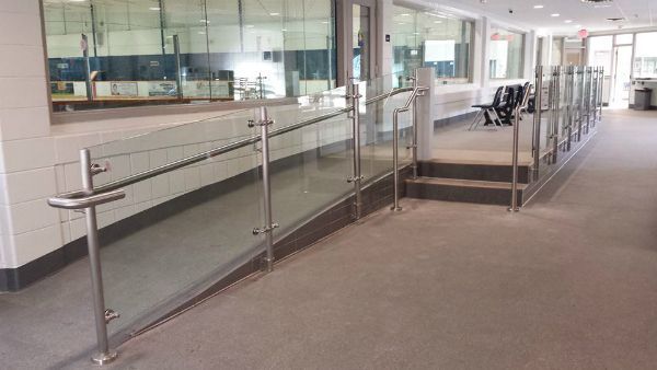 A hallway with stairs and a glass railing in a building.