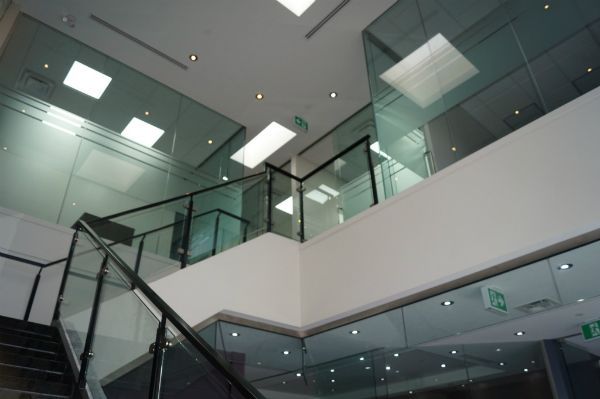 A staircase in a building with a glass railing