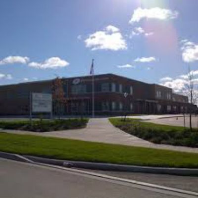 A large brick building with a flag pole in front of it.
