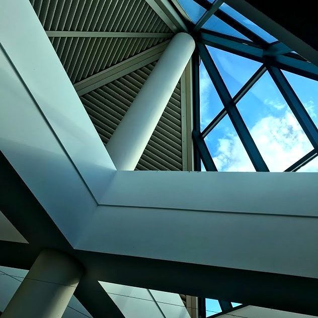 Looking up at the ceiling of a building with a blue sky in the background