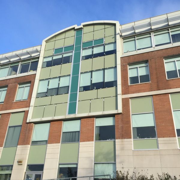 A large building with a lot of windows and a blue sky in the background
