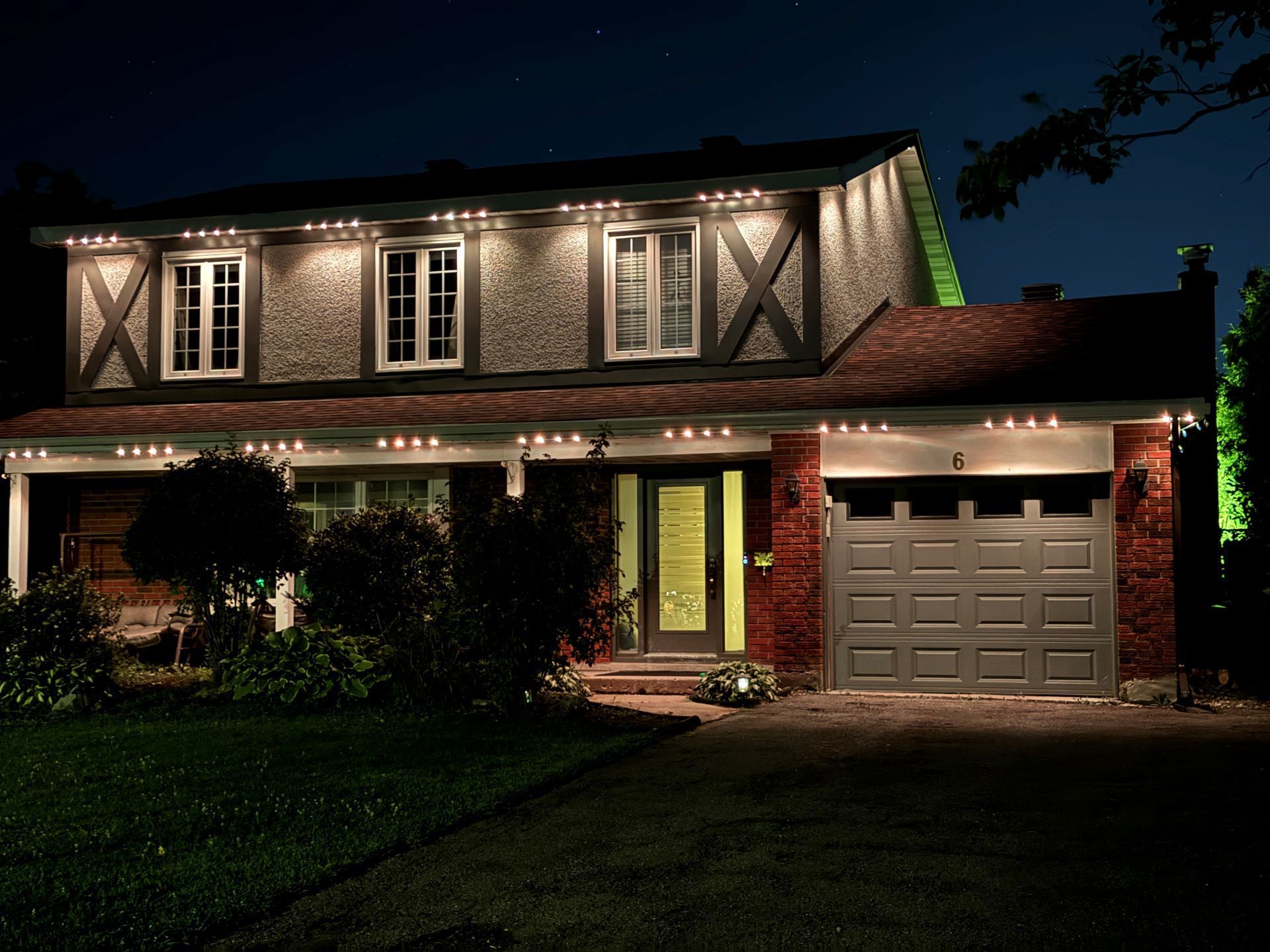 A house is lit up at night with green lights