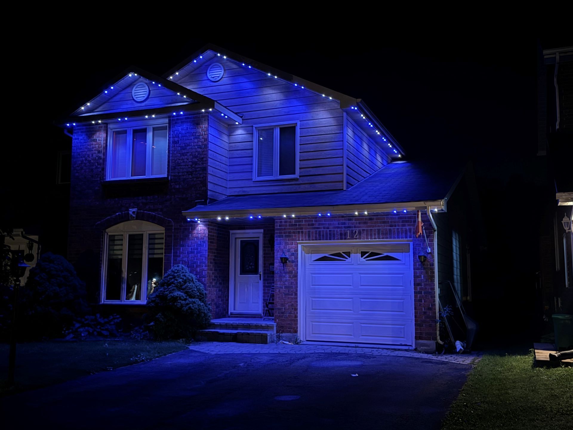 A house is lit up with blue lights at night.