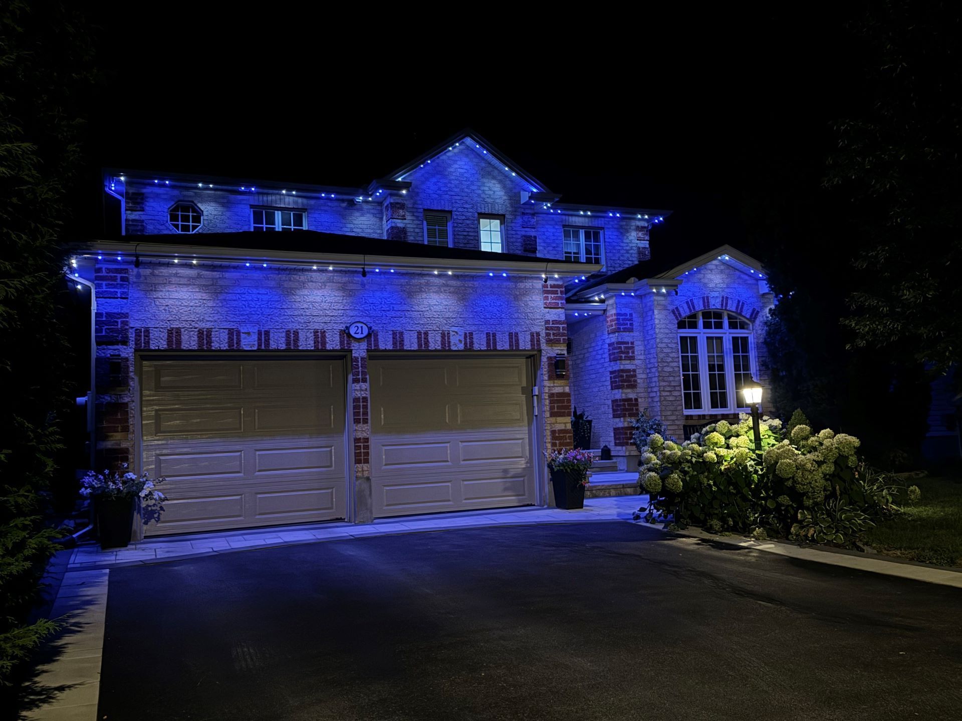A house with blue lights on it is lit up at night.