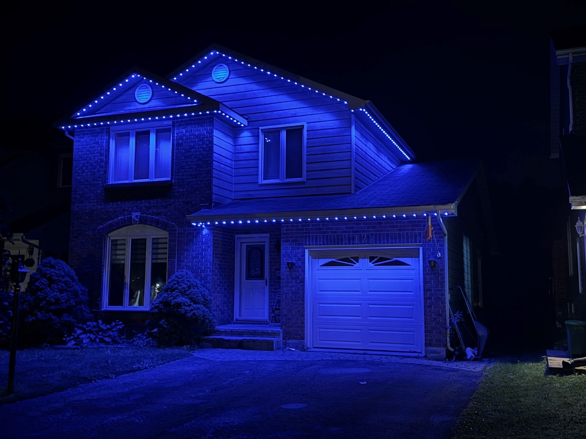 A house is lit up with blue lights at night.