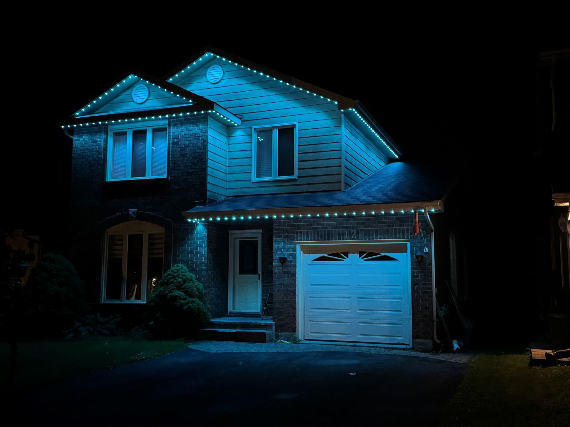 A house with blue lights on it is lit up at night.