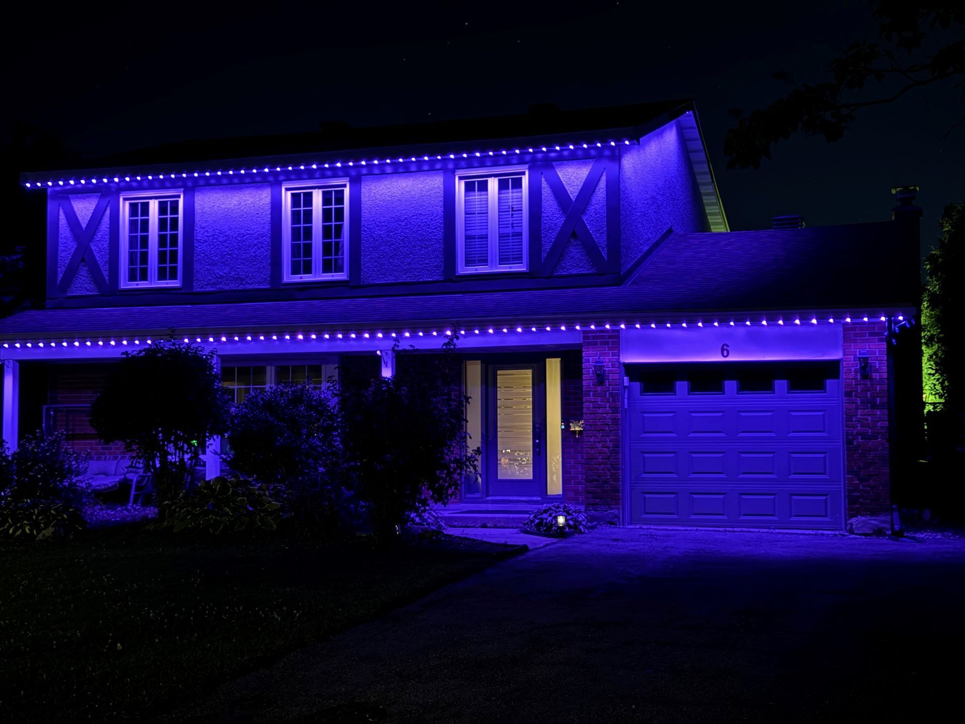 A house is lit up with purple lights at night