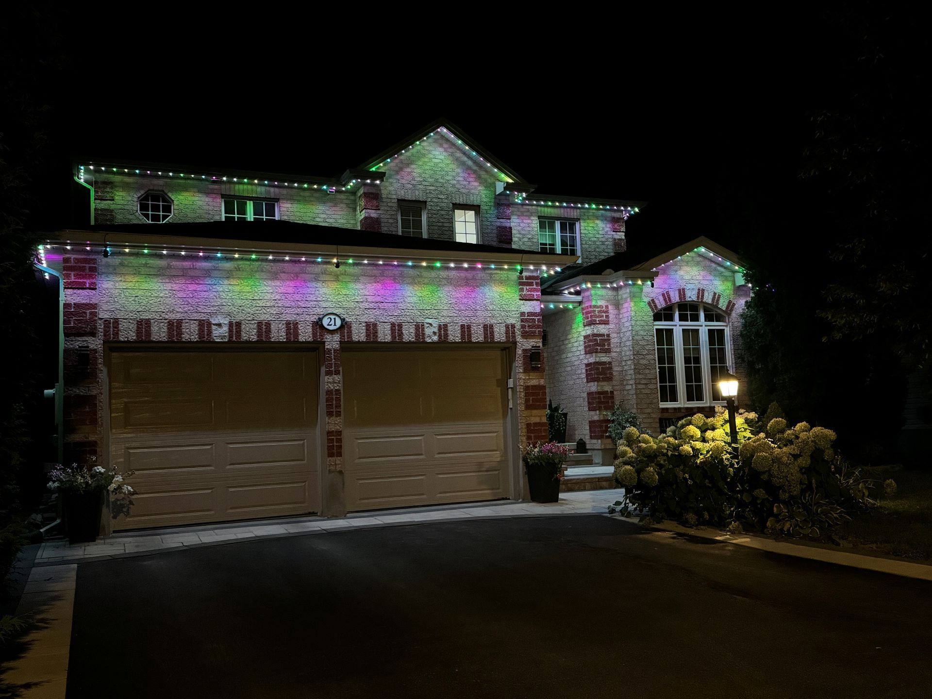 A house with christmas lights on it is lit up at night.