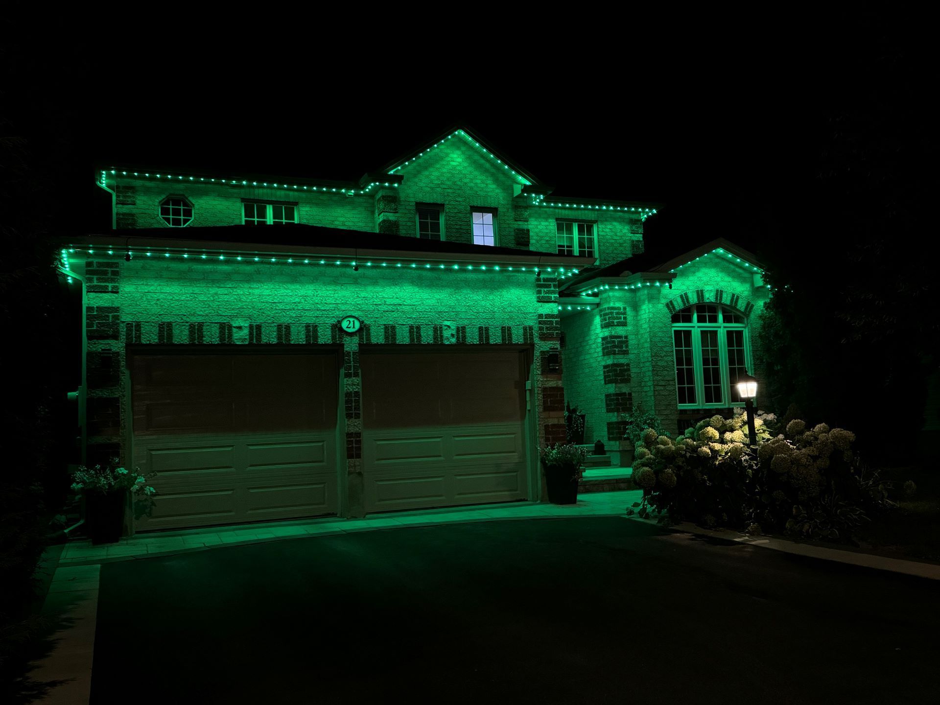 A house is lit up with green lights at night.