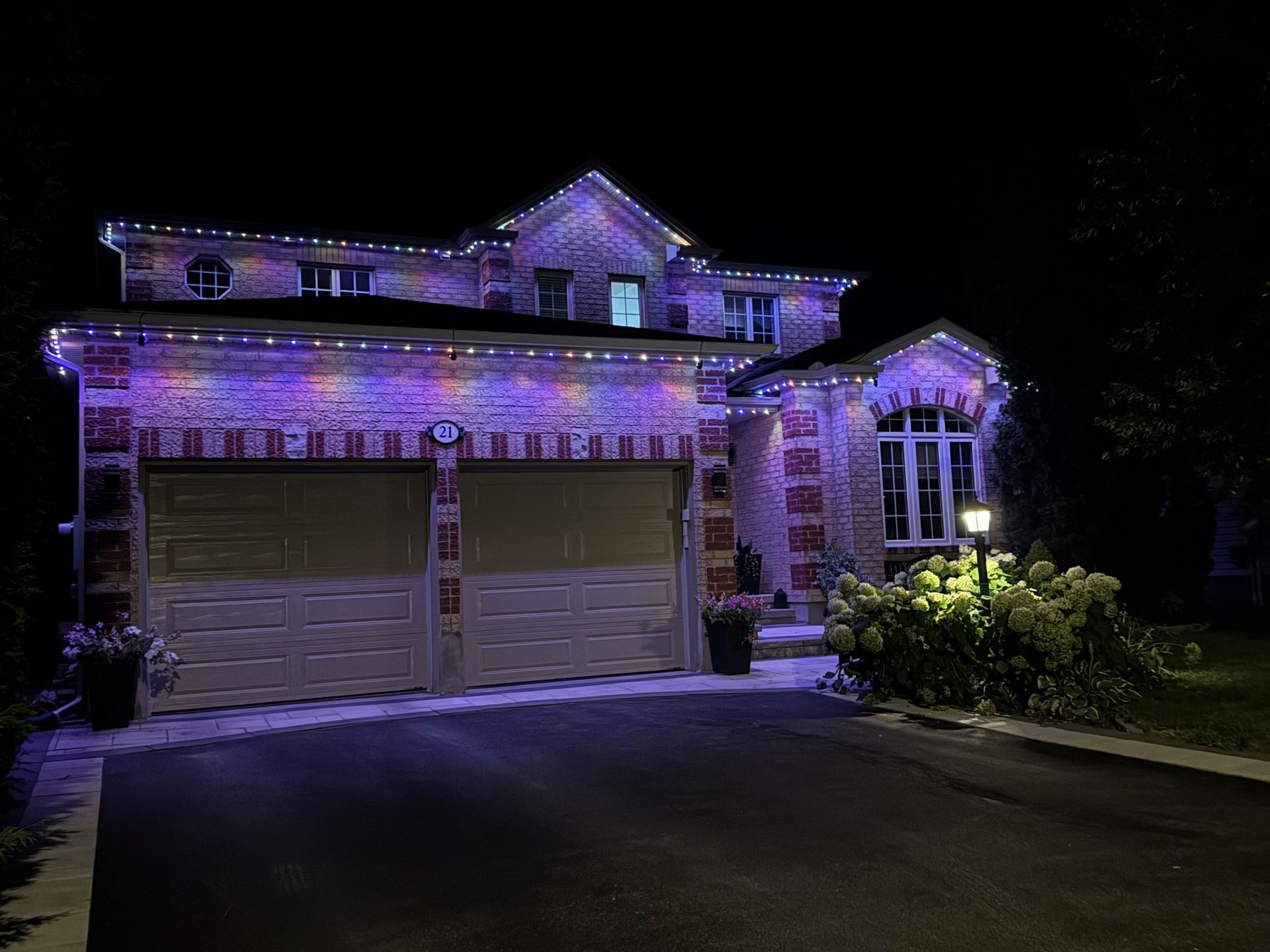 A large house is lit up with purple lights at night.