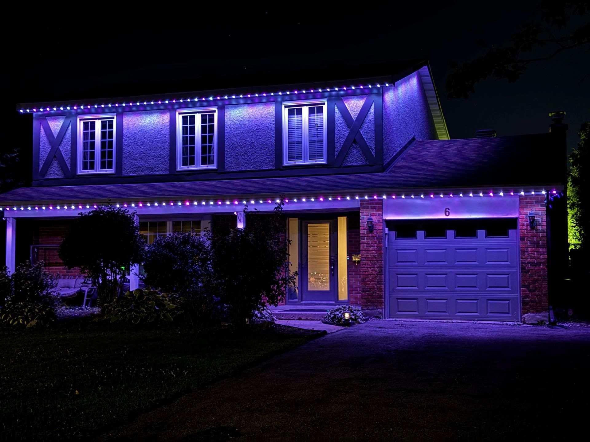 A house is lit up with purple lights at night