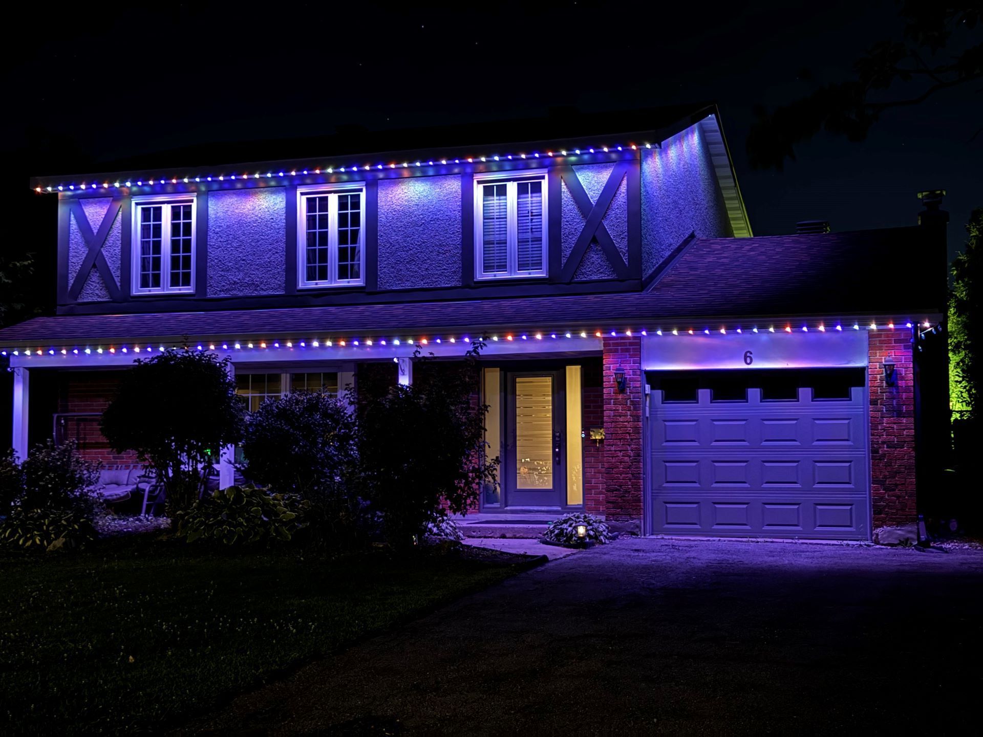 A house is lit up with purple lights at night
