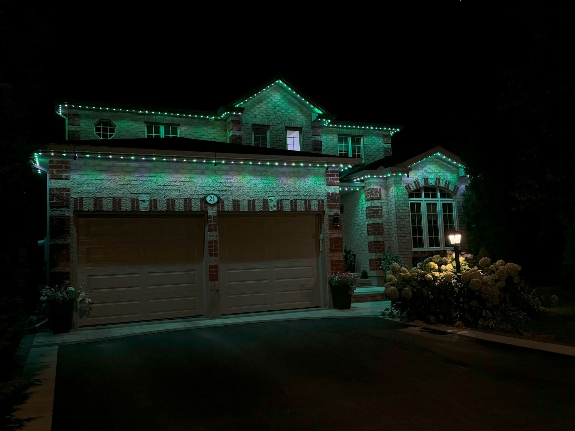 A house with green lights on it is lit up at night.