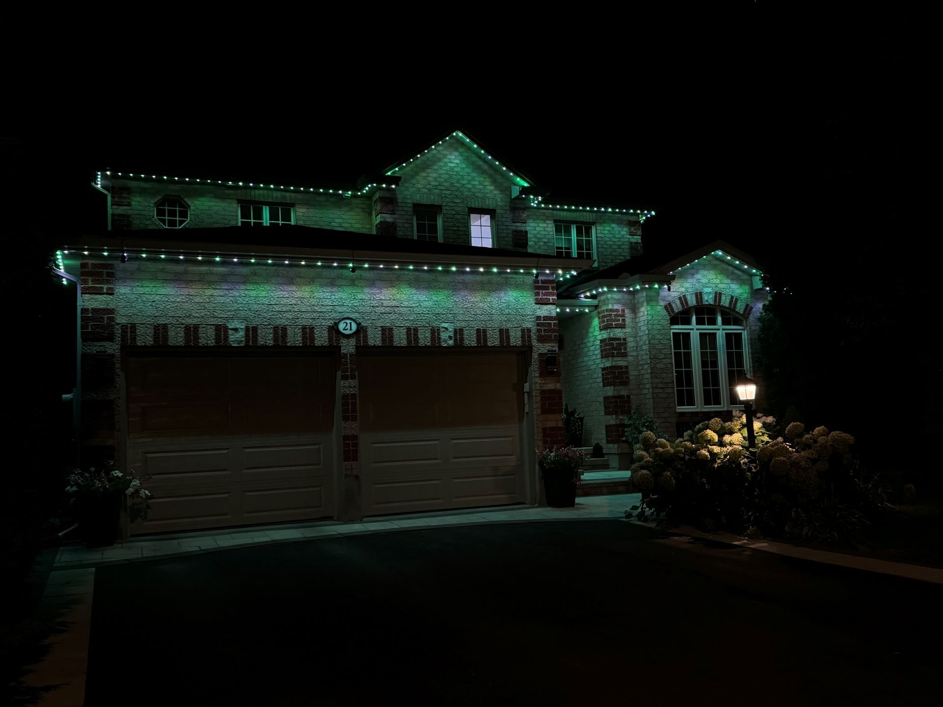 A house with christmas lights on it is lit up at night.