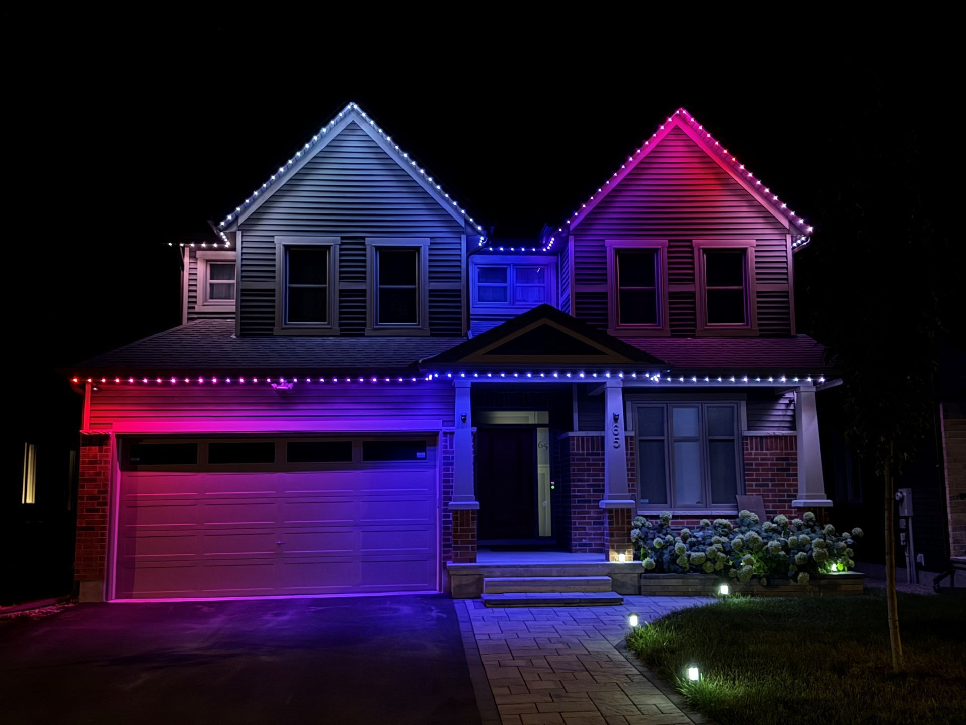 A house is lit up with purple and blue lights at night.