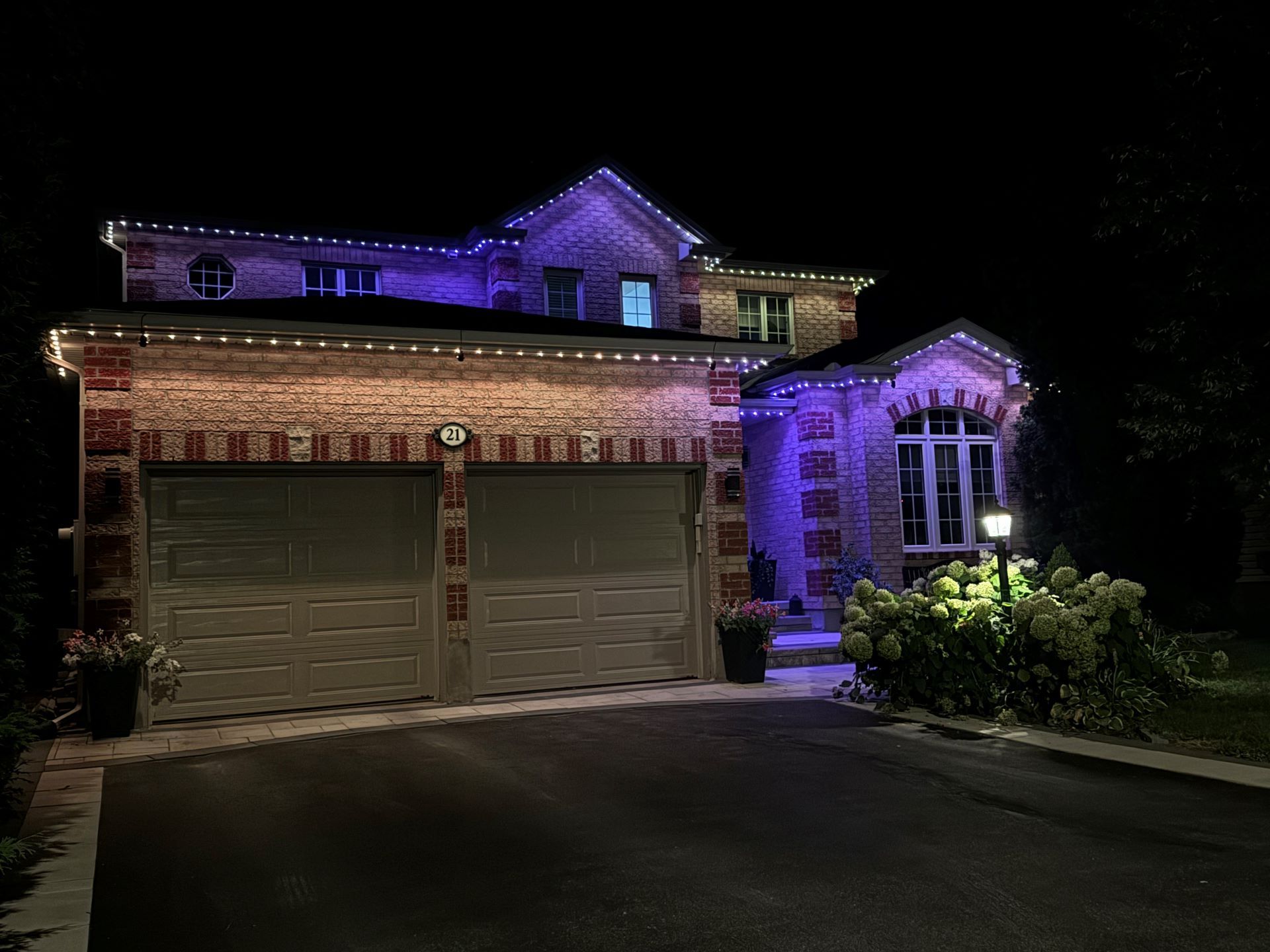 A house is lit up with purple lights at night.