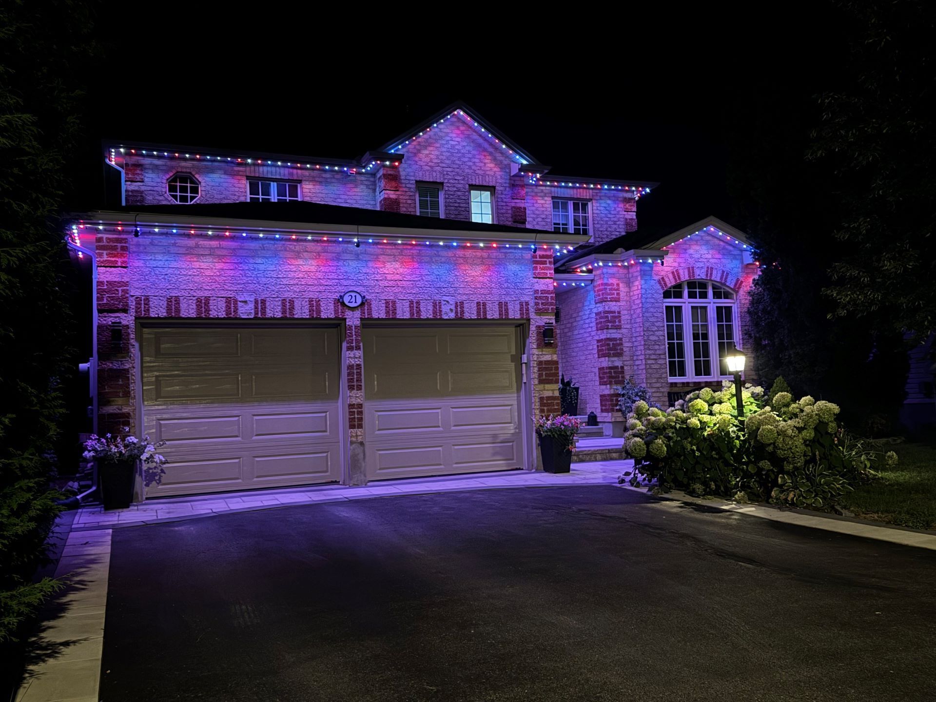 A house with christmas lights on it is lit up at night.