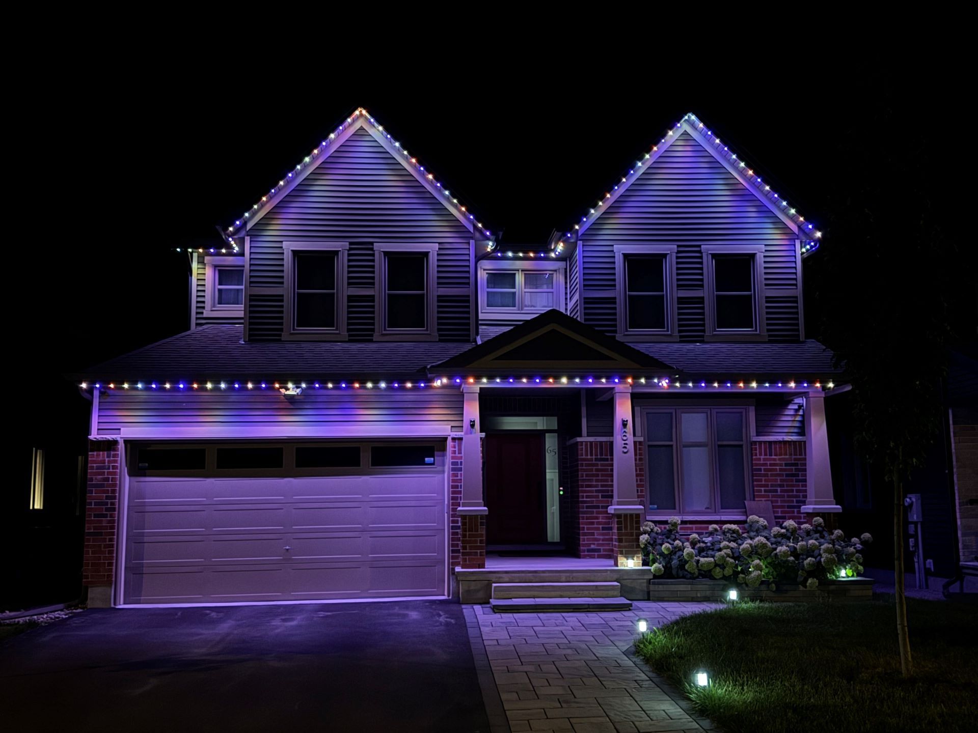 A house is lit up with purple lights at night.