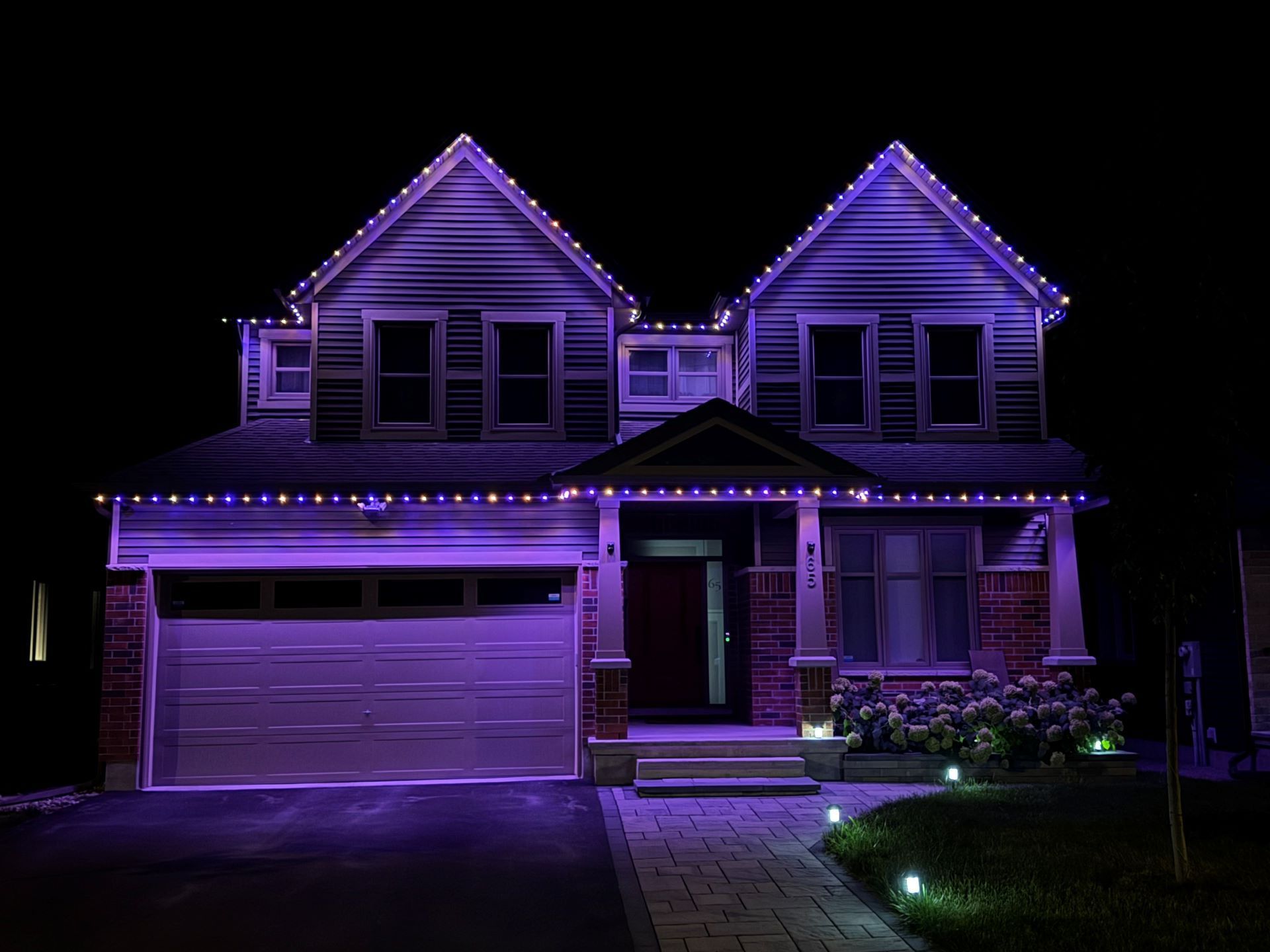 A house is lit up with purple lights at night.