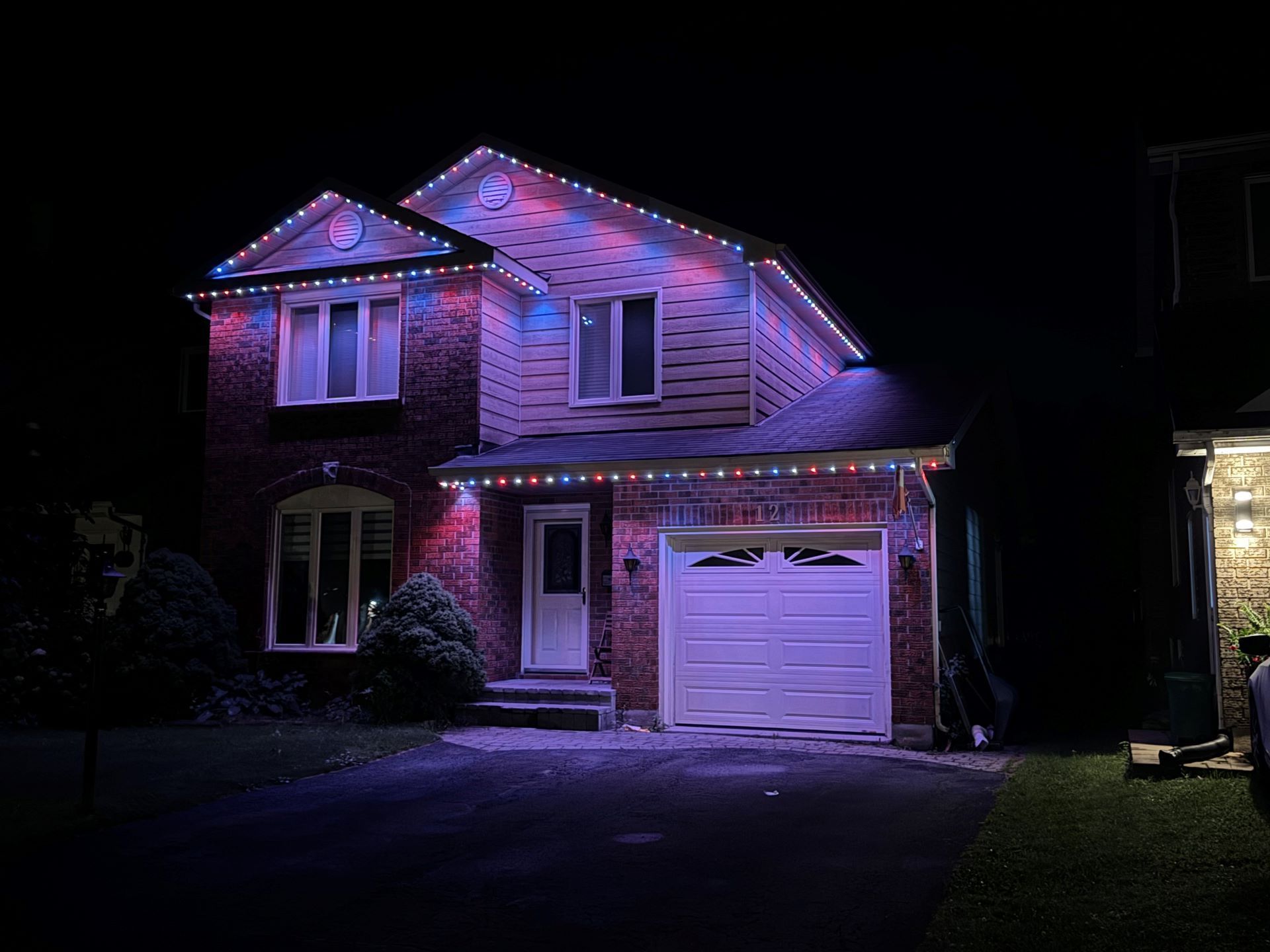 A house is lit up with christmas lights at night.