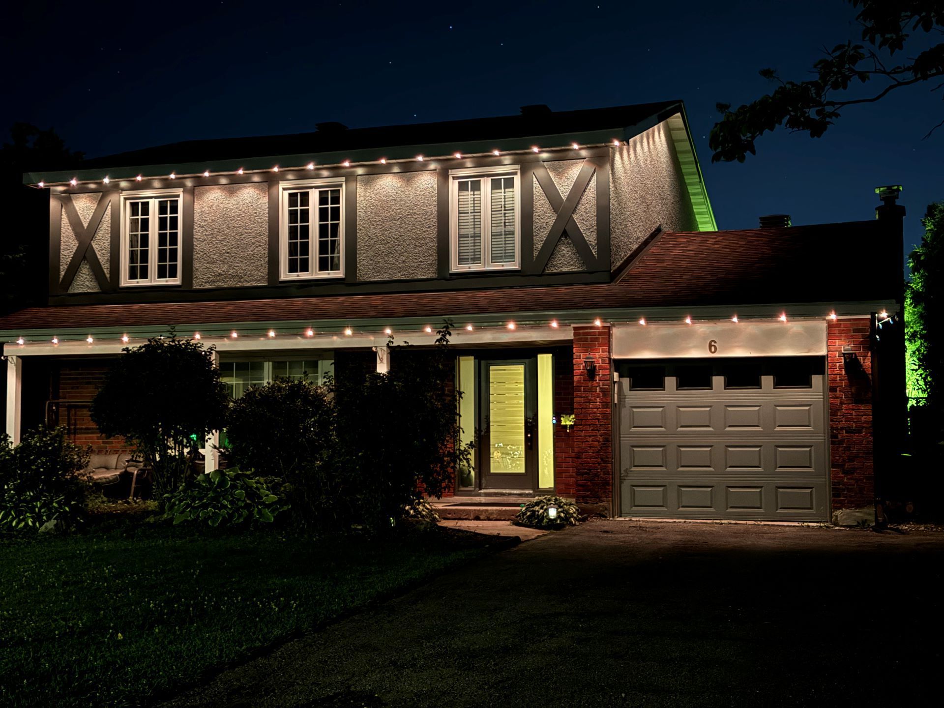 A house is lit up at night with green lights