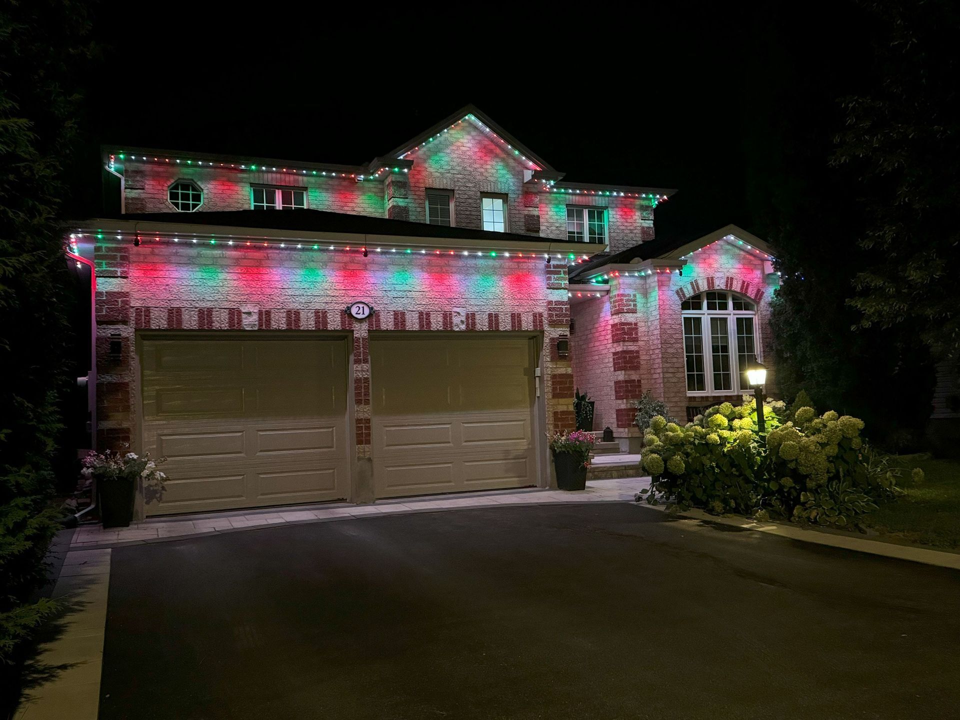 A house with christmas lights on it is lit up at night.