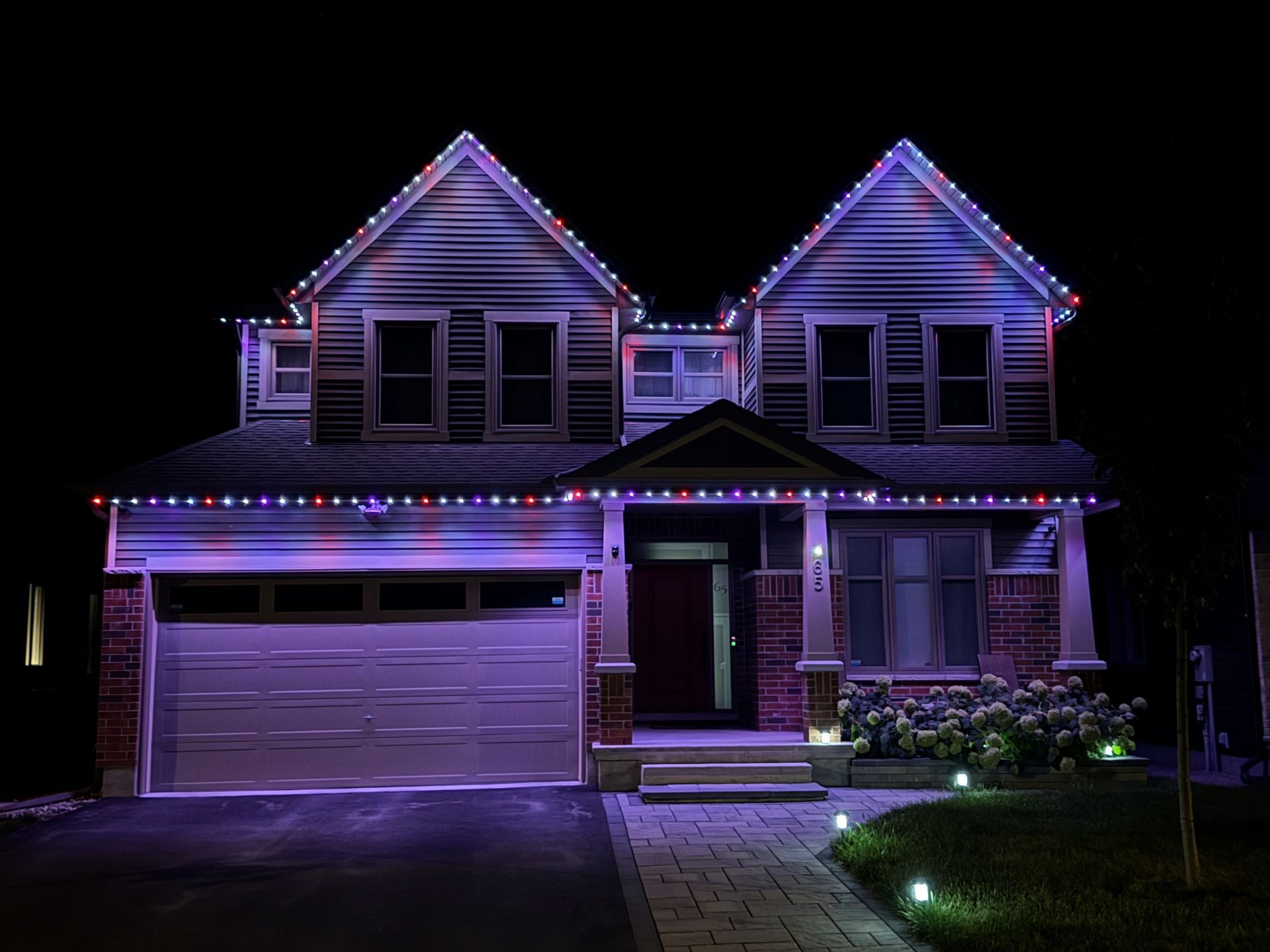 A house is lit up with christmas lights at night.