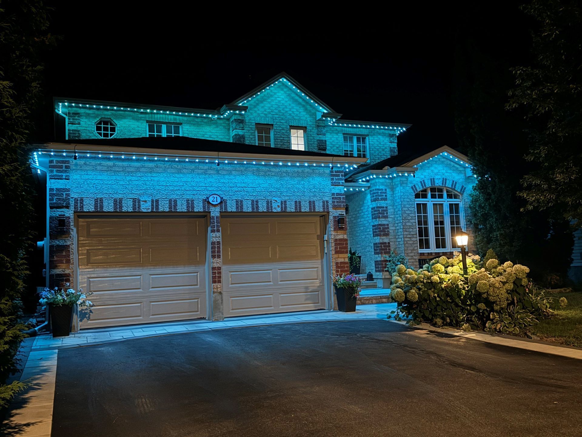 A large house is lit up with blue lights at night.