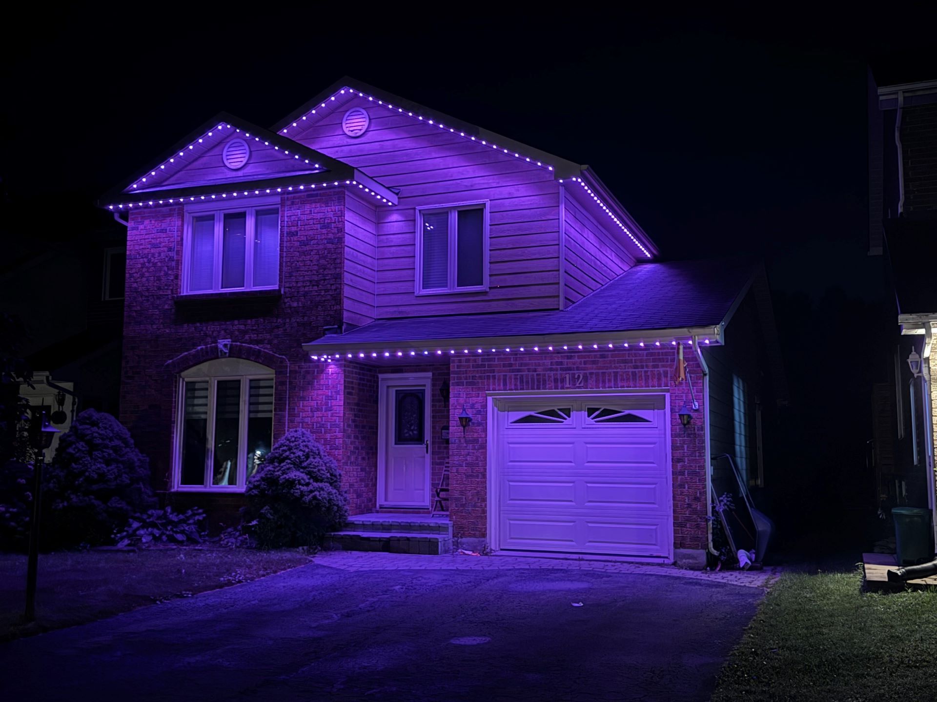 A house is lit up with purple lights at night.